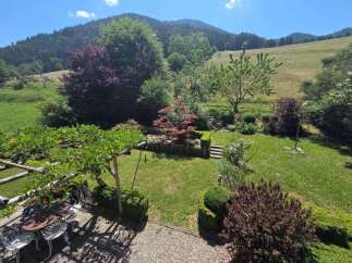 Escape to this idyllic property featuring a charming garden with a pergola-covered patio, perfect for outdoor dining and relaxation.