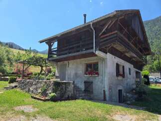 Charming rustic property nestled in a serene mountain landscape, perfect for a getaway.