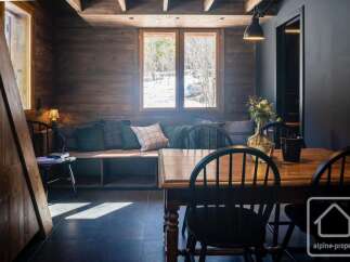 Experience cozy mountain living in this charming dining area, featuring rustic wooden walls and a built-in bench with plush cushions.