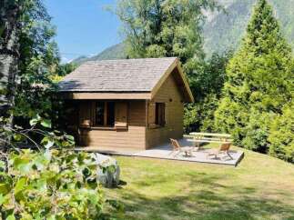 Nestled amidst lush greenery and towering trees, this charming wooden cabin offers a serene mountain retreat.