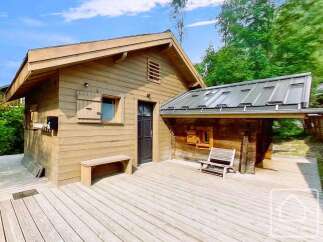 Experience rustic charm with this wooden cabin featuring a spacious deck perfect for outdoor relaxation.