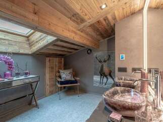 Experience rustic luxury in this unique bathroom featuring a stunning wooden ceiling and exposed beams.