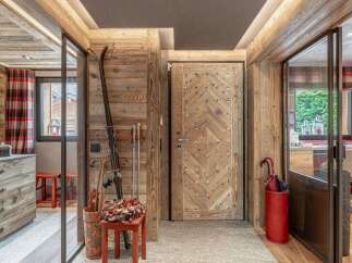 Experience rustic charm in this mountain retreat, featuring a stunning wooden door with diamond-patterned accents and ski equipment ready for adventure.
