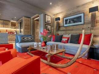 Experience luxury mountain living in this stunning chalet, featuring a cozy living area with a unique sled-inspired coffee table and plush seating.