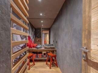 Discover this unique hallway featuring a rustic wooden slatted screen and a textured grey wall, creating a warm and inviting atmosphere.