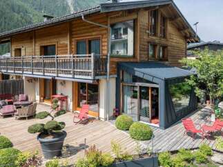 Experience luxury mountain living in this stunning wooden chalet, featuring a spacious multi-level deck perfect for outdoor entertaining.