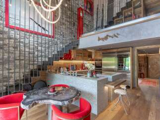 Experience luxury mountain living in this stunning multi-level residence, featuring a modern kitchen with high-end appliances and a sleek granite island.