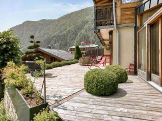 Experience breathtaking mountain views from this stunning wooden deck, perfect for outdoor relaxation and entertaining.