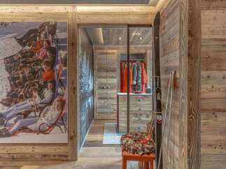 Experience rustic charm and modern convenience in this mountain retreat, featuring a striking vintage ski-themed artwork and a spacious walk-in closet.