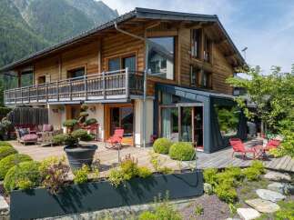 Experience luxury mountain living in this stunning wooden chalet, featuring a spacious multi-level deck perfect for entertaining or enjoying the breathtaking alpine views.