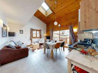Experience cozy mountain living in this charming alpine apartment, featuring a vaulted wooden ceiling and a skylight that floods the space with natural light.