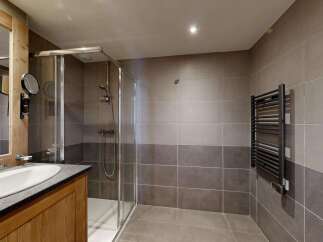 Experience modern comfort in this beautifully appointed bathroom, featuring a sleek glass-enclosed shower and a stylish vanity with a vessel sink.