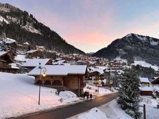 Experience the charm of a winter wonderland with this stunning alpine village scene.