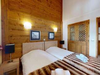 Experience rustic charm in this cozy bedroom featuring two twin beds adorned with plush throws and soft linens.