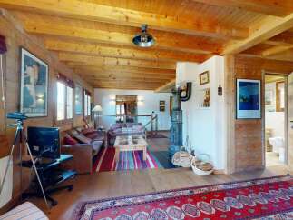 Experience rustic charm in this mountain chalet featuring exposed wooden beams and a cozy fireplace.