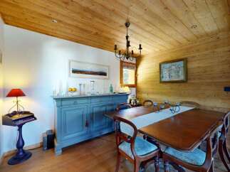 Experience rustic charm in this dining room, featuring a warm wooden ceiling and walls that create a cozy alpine ambiance.