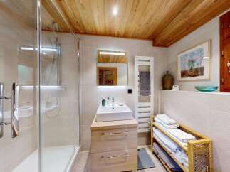 Experience modern comfort in this beautifully appointed bathroom, featuring a sleek glass-enclosed shower and a stylish vanity with ample storage.