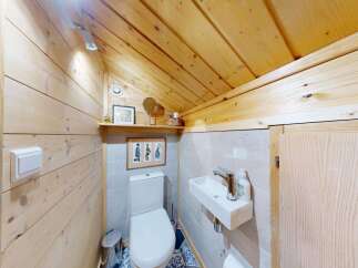 This charming bathroom features rustic wooden walls and ceiling, creating a warm and inviting atmosphere.