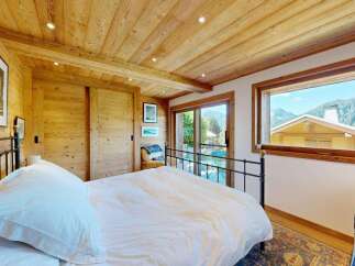 Experience mountain living in this charming bedroom featuring a cozy wooden interior and stunning panoramic views.