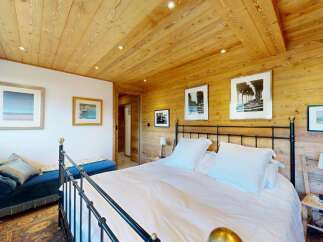 Experience rustic charm in this beautifully appointed bedroom, featuring warm wooden walls and ceiling.