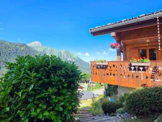 Experience breathtaking mountain views from this charming wooden chalet, perfect for a serene getaway.