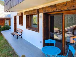 Experience the charm of this alpine retreat, featuring rustic wooden accents and a serene outdoor patio.