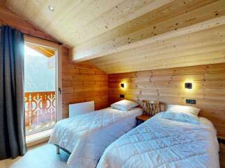 Experience cozy mountain living in this charming bedroom featuring two twin beds with crisp white linens and quilted comforters.