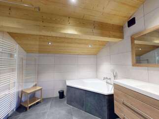 Experience luxury in this modern bathroom featuring a spacious corner bathtub perfect for relaxation.