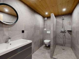 Experience modern mountain living in this stunning bathroom featuring a sleek vanity, a spacious walk-in shower, and a minimalist toilet.