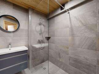 Experience modern luxury in this stunning bathroom featuring a sleek vanity with ample storage and a spacious walk-in shower with elegant stone tilework.