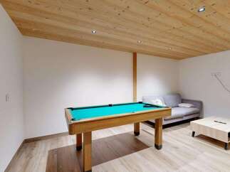 This inviting room features a classic wooden pool table with a vibrant green felt surface, perfect for entertainment.