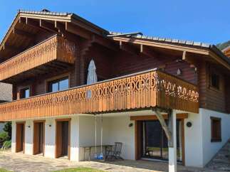 Experience alpine living in this charming wooden chalet, featuring intricate carved balconies perfect for enjoying mountain views.