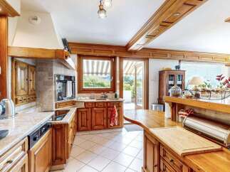 Experience the charm of this rustic kitchen, featuring custom wooden cabinetry and granite countertops.