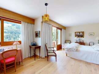 Experience breathtaking mountain views from this charming bedroom, featuring a large window overlooking a scenic landscape.