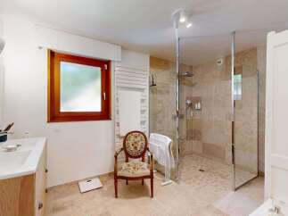 This modern bathroom features a spacious walk-in shower with elegant stone tiling and a sleek glass enclosure.