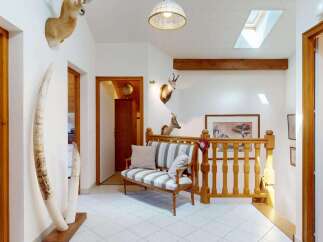 Step into this unique entryway featuring a charming striped bench and striking decorative tusks.