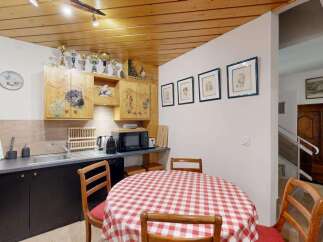 Charming kitchen with rustic wooden cabinets featuring decorative mountain scenes and wildlife motifs.