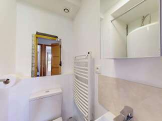 This modern bathroom features a sleek toilet and a convenient toilet paper holder.