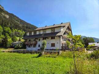 Discover this charming multi-story apartment building nestled in a picturesque mountain setting.