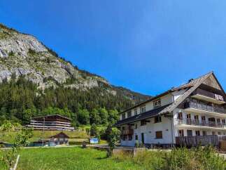 Discover this charming multi-story building nestled against a majestic mountain backdrop, perfect for a serene getaway.