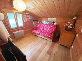 Cozy attic room featuring a charming pink floral sofa, perfect for relaxing.