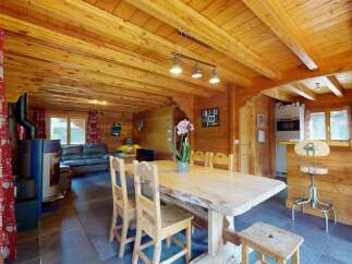 Experience rustic charm in this cozy log cabin dining area, featuring a live-edge wooden table perfect for family gatherings.
