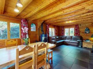 Experience rustic charm in this cozy log cabin living and dining area.