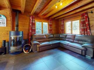Experience rustic charm in this cozy log cabin living room, featuring a spacious sectional sofa perfect for relaxation.