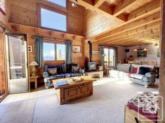 Experience rustic charm in this inviting log cabin living room, featuring a cozy fireplace and ample natural light.
