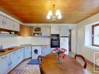 Discover this charming kitchen featuring light blue cabinetry and a warm wooden ceiling.