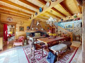 Experience rustic charm in this inviting dining area, featuring a warm wooden interior and a cozy fireplace.