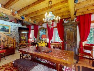 Step into a charming rustic dining room featuring a large wooden table with a unique tiled top, perfect for family gatherings.