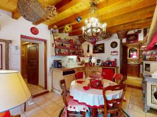 Charming rustic kitchen featuring exposed wooden beams and a traditional chandelier.