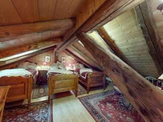 Discover this charming attic bedroom featuring two cozy single beds, perfect for guests or family.